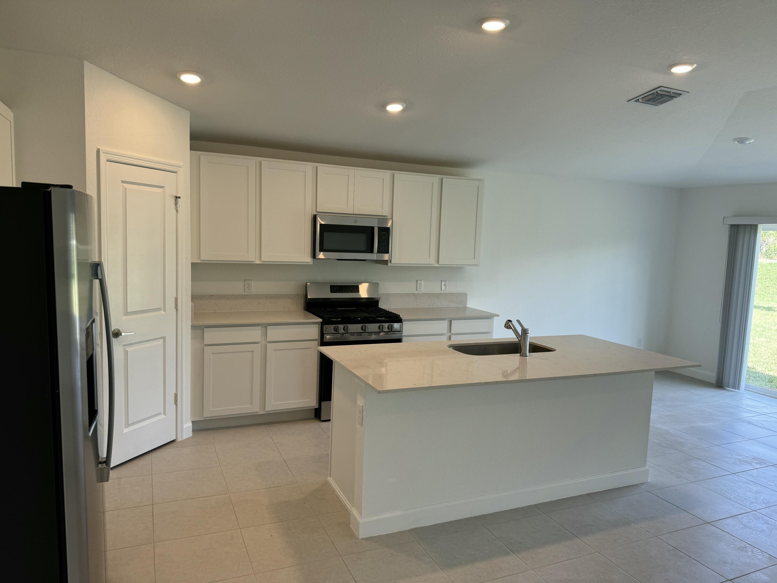 10445 Northwest Suncrest Loop Port Port St. Lucie, FL 34987 - Photo 14 of 45 a kitchen with a sink appliances and cabinets