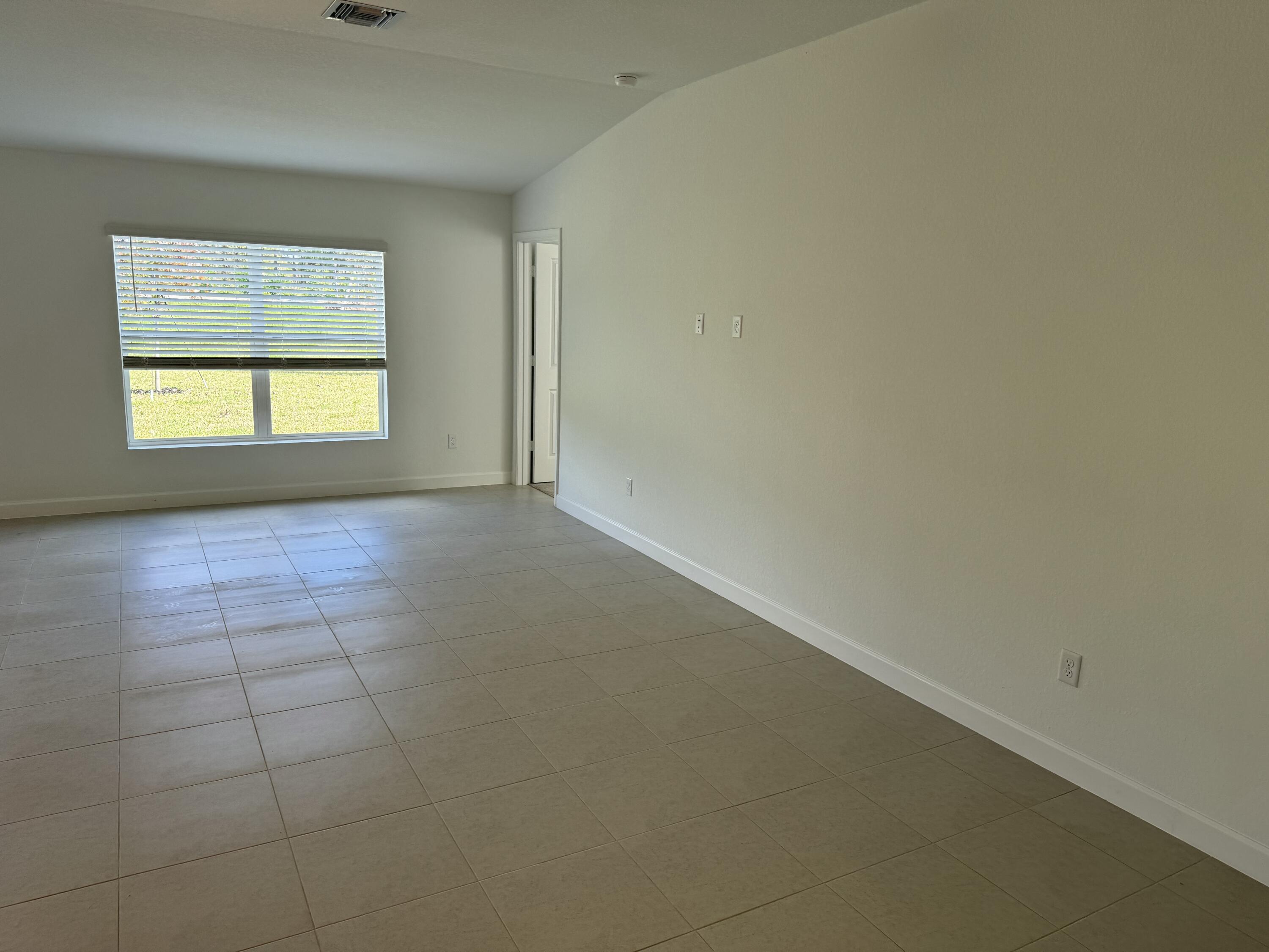 10445 Northwest Suncrest Loop Port Port St. Lucie, FL 34987 - Photo 16 of 45 an empty room with a window