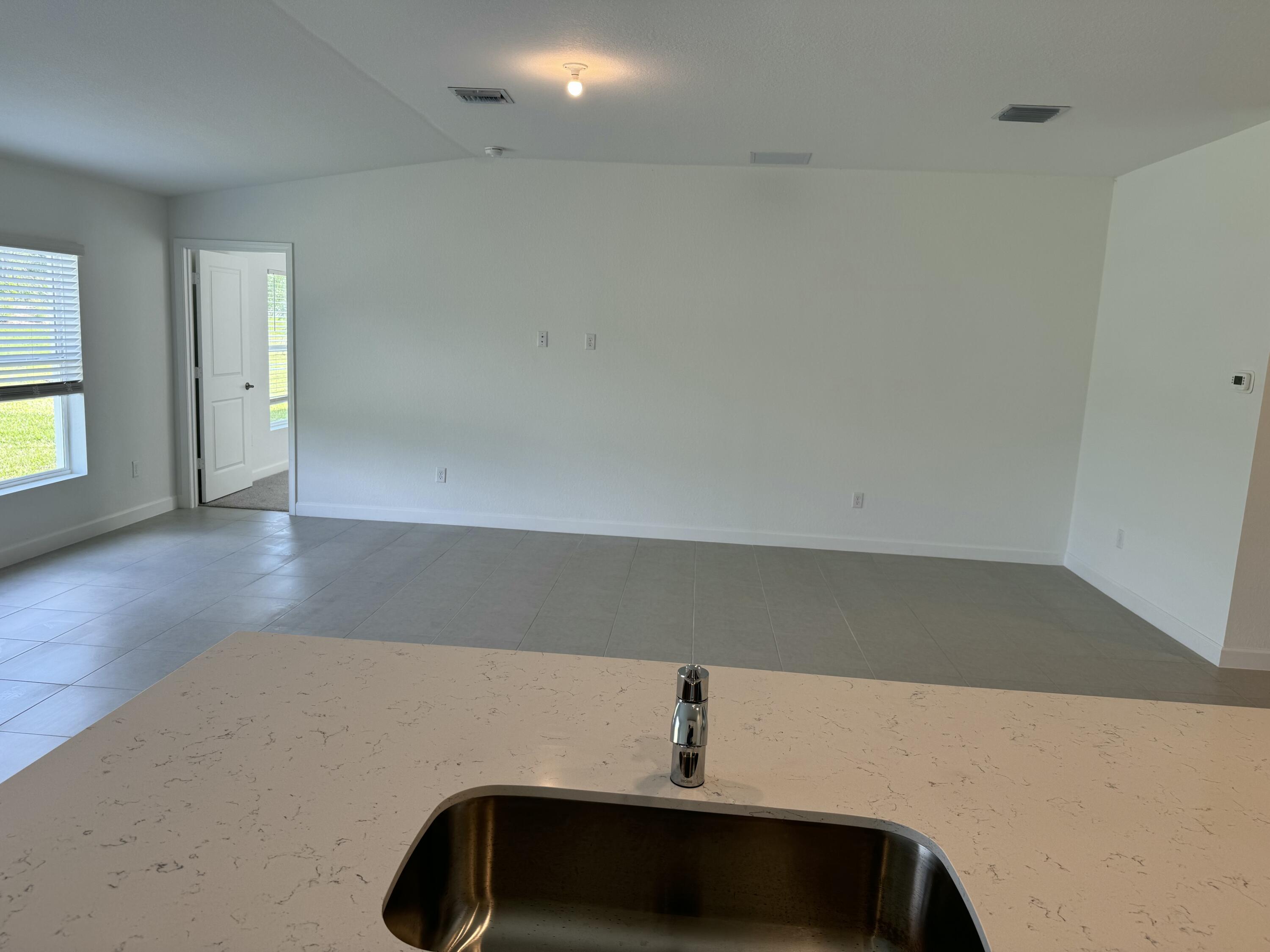 10445 Northwest Suncrest Loop Port Port St. Lucie, FL 34987 - Photo 21 of 45 a view of an empty room and wooden floor