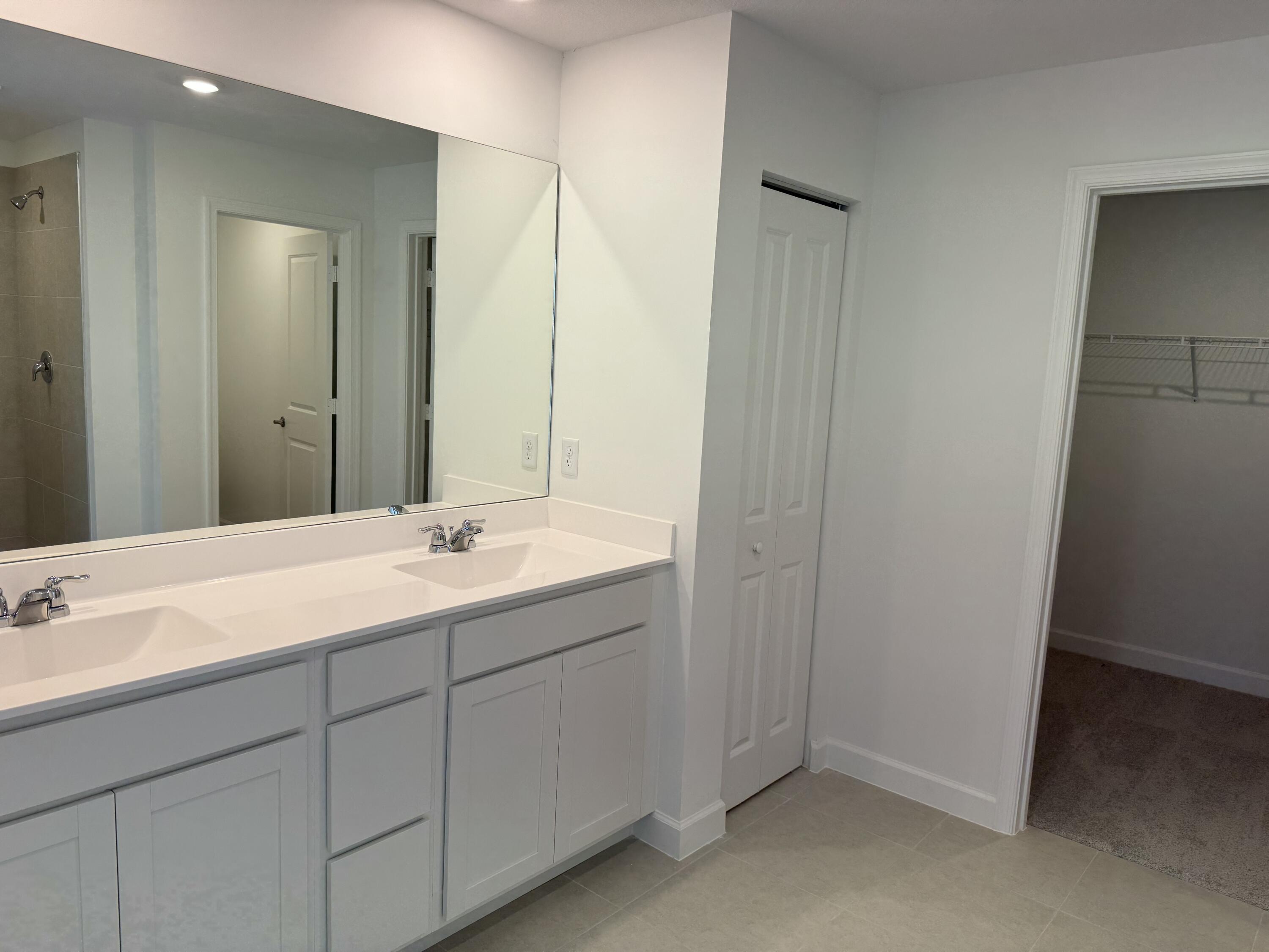 10445 Northwest Suncrest Loop Port Port St. Lucie, FL 34987 - Photo 24 of 45 a bathroom with a sink and a mirror