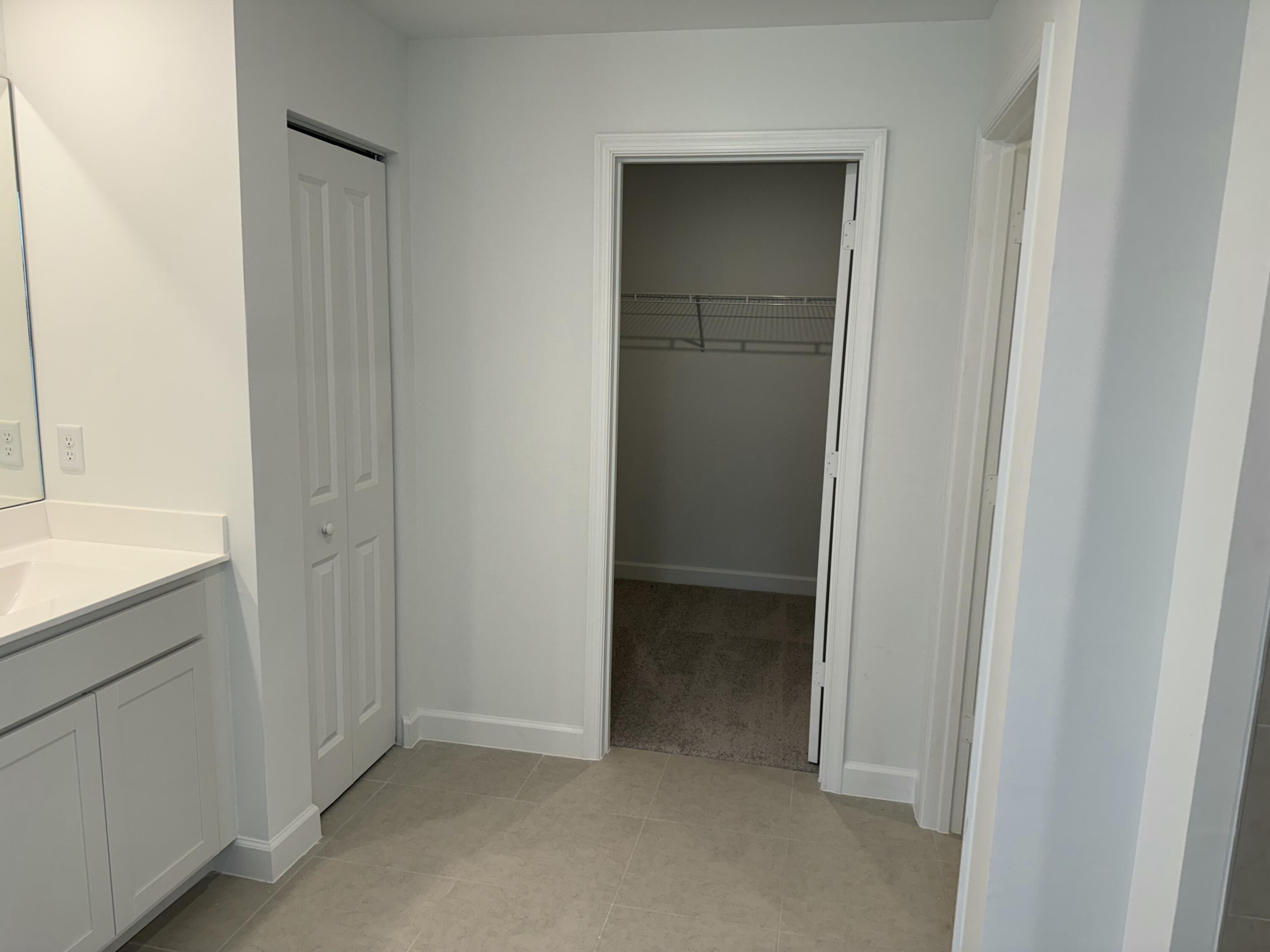 10445 Northwest Suncrest Loop Port Port St. Lucie, FL 34987 - Photo 25 of 45 a view of a bathroom from a hallway