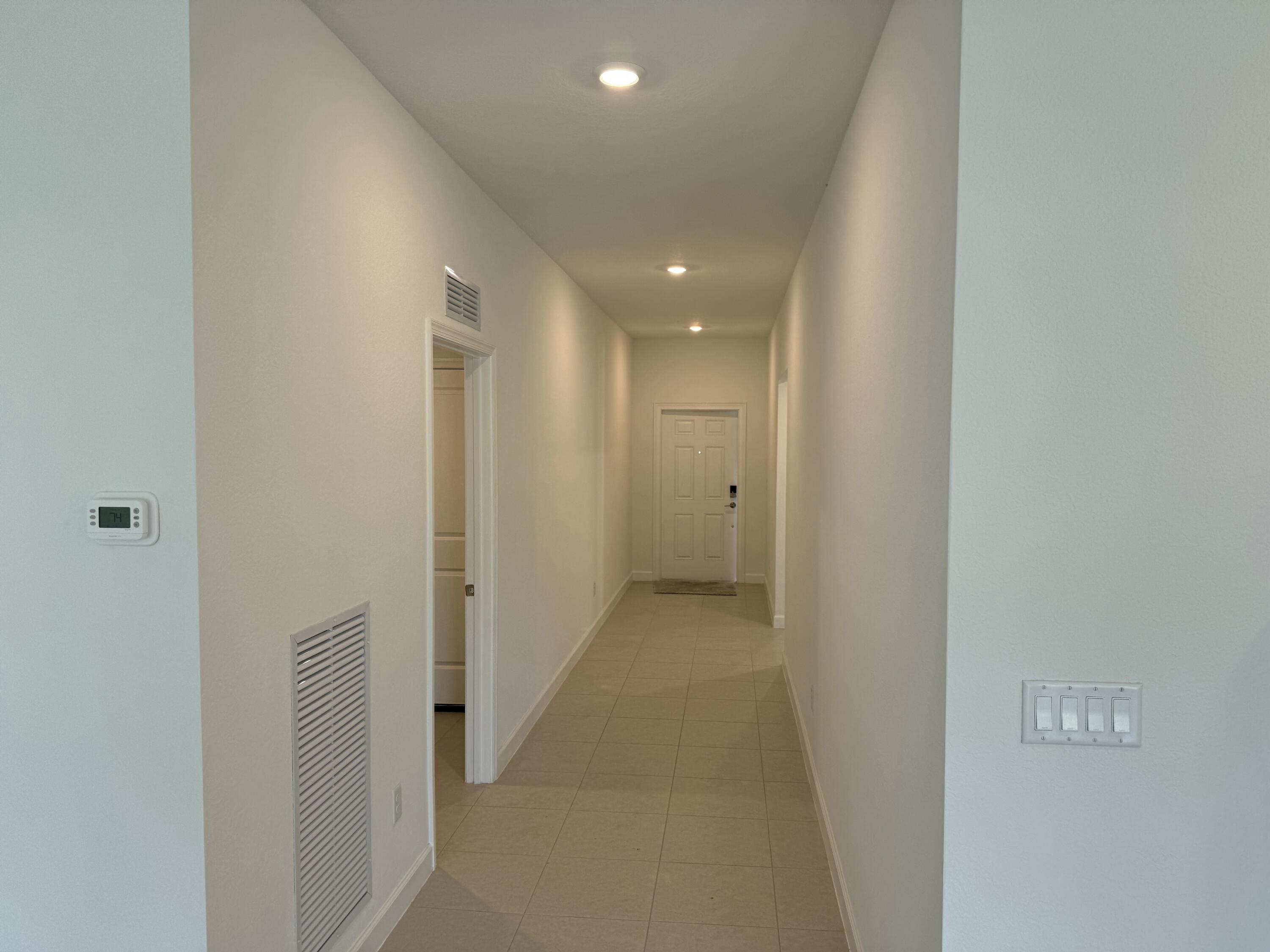 10445 Northwest Suncrest Loop Port Port St. Lucie, FL 34987 - Photo 6 of 45 a view of a hallway with wooden floor