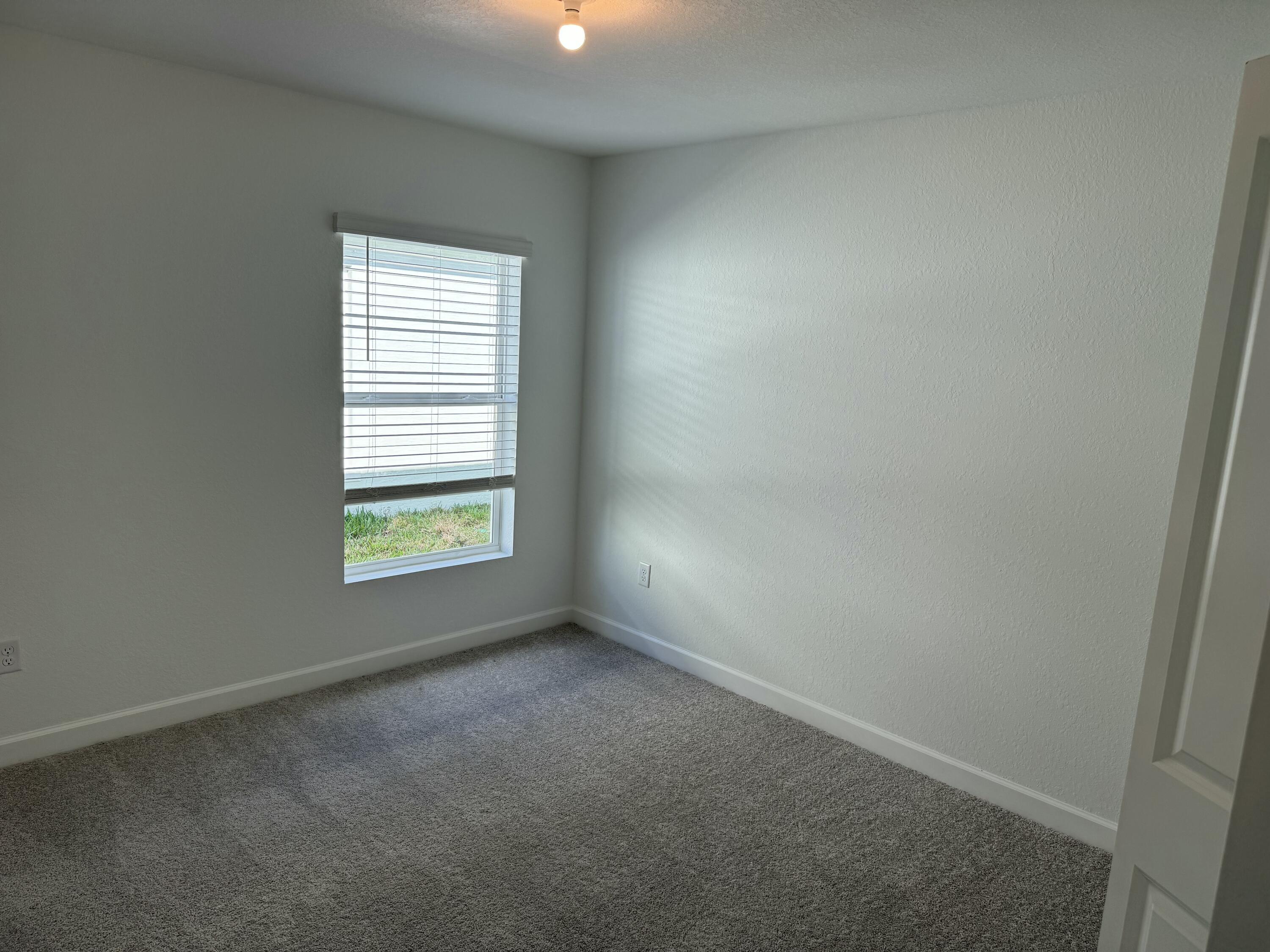 10445 Northwest Suncrest Loop Port Port St. Lucie, FL 34987 - Photo 7 of 45 an empty room with a window