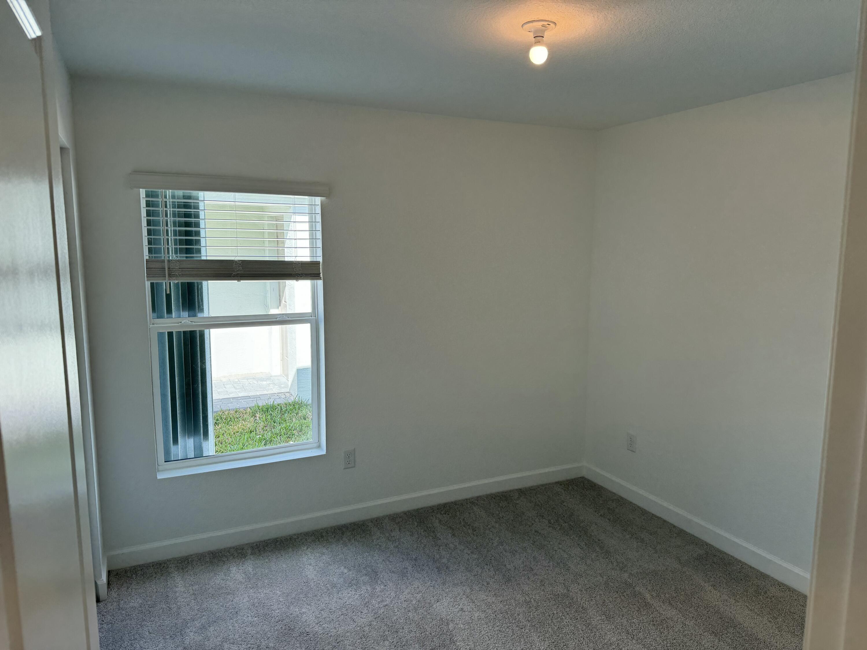10445 Northwest Suncrest Loop Port Port St. Lucie, FL 34987 - Photo 9 of 45 an empty room with a window