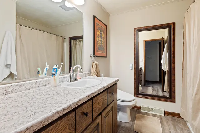 a bathroom with a granite countertop sink and a mirror with toilet