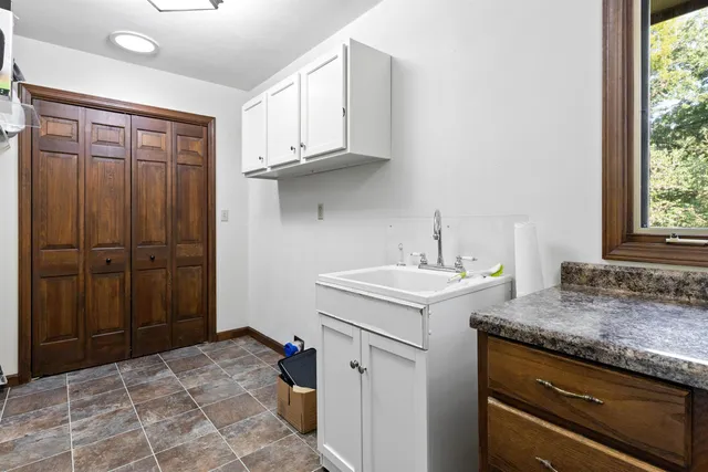 a utility room with granite countertop a sink and a refrigerator