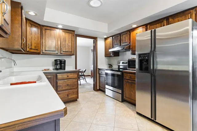 a kitchen with granite countertop stainless steel appliances and refrigerator