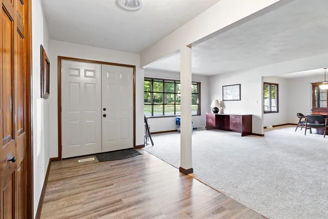 a view of a livingroom with wooden floor and furniture