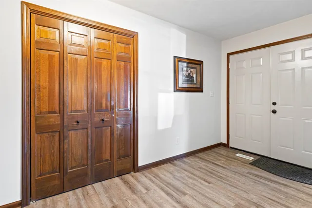 an empty room with wooden floor and closet