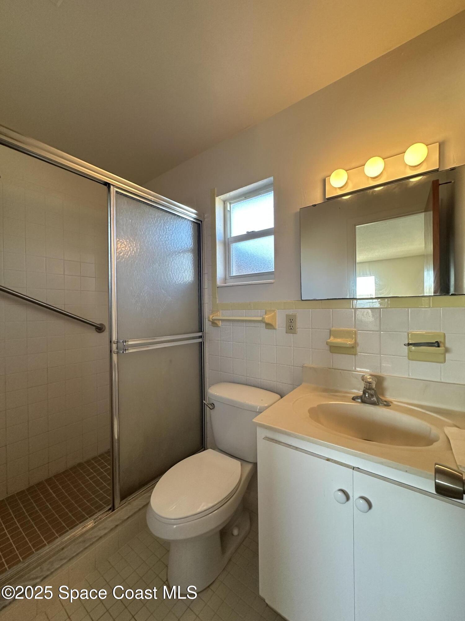 905 Grant Road Titusville, FL 32780 - Photo 11 of 30 a bathroom with a sink toilet and shower
