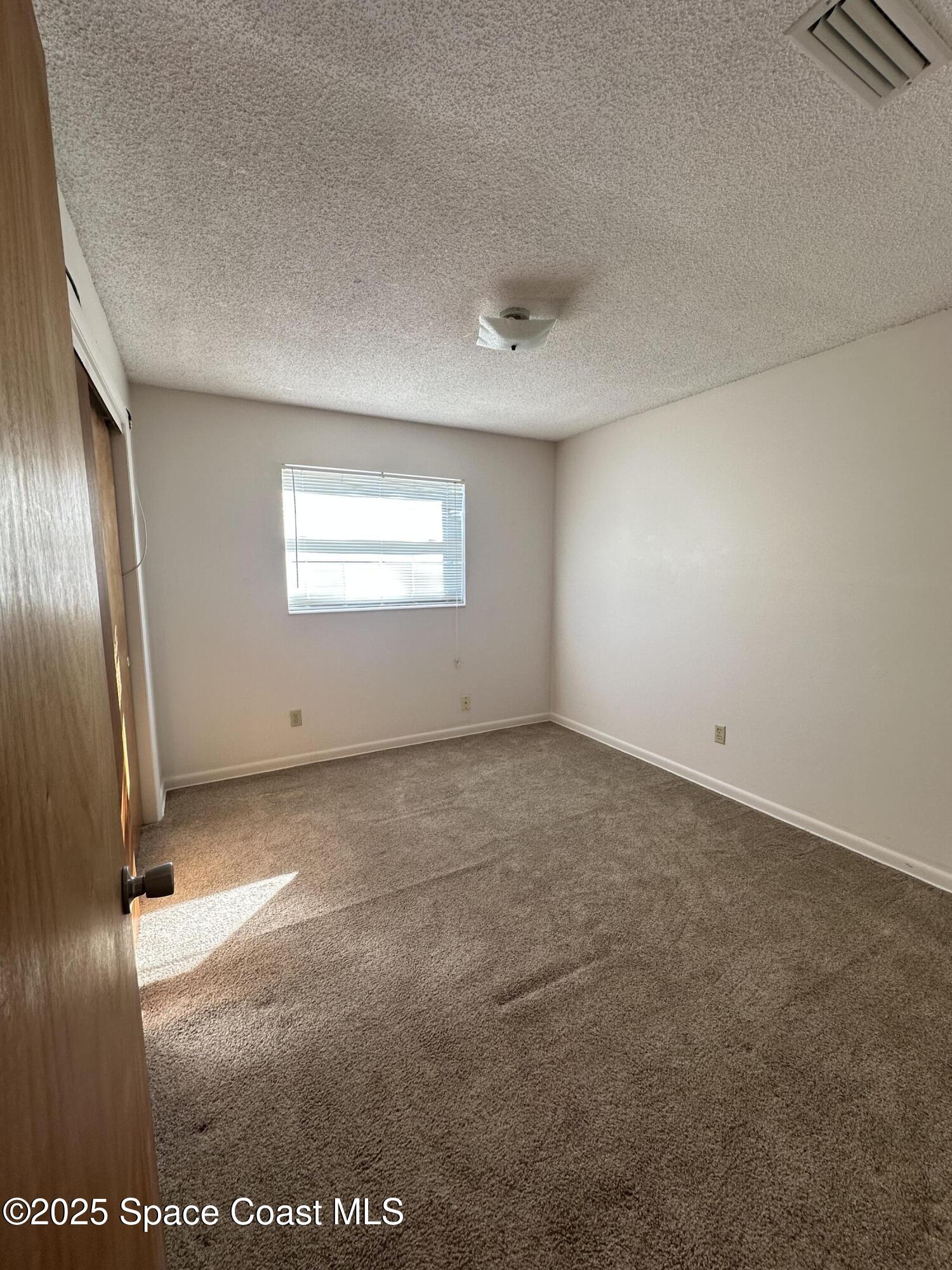 905 Grant Road Titusville, FL 32780 - Photo 13 of 30 an empty room with windows