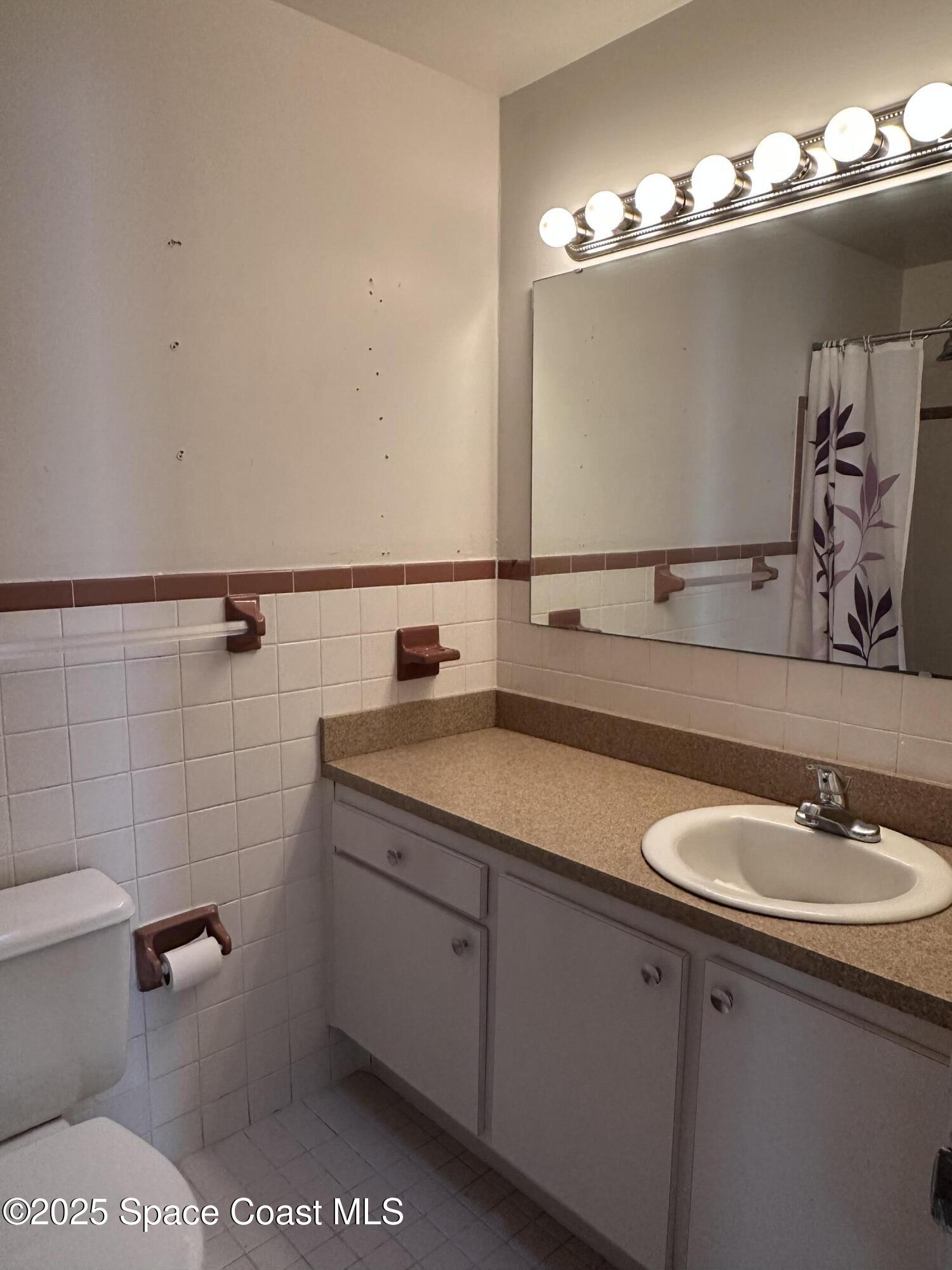 905 Grant Road Titusville, FL 32780 - Photo 15 of 30 a bathroom with a sink and mirror