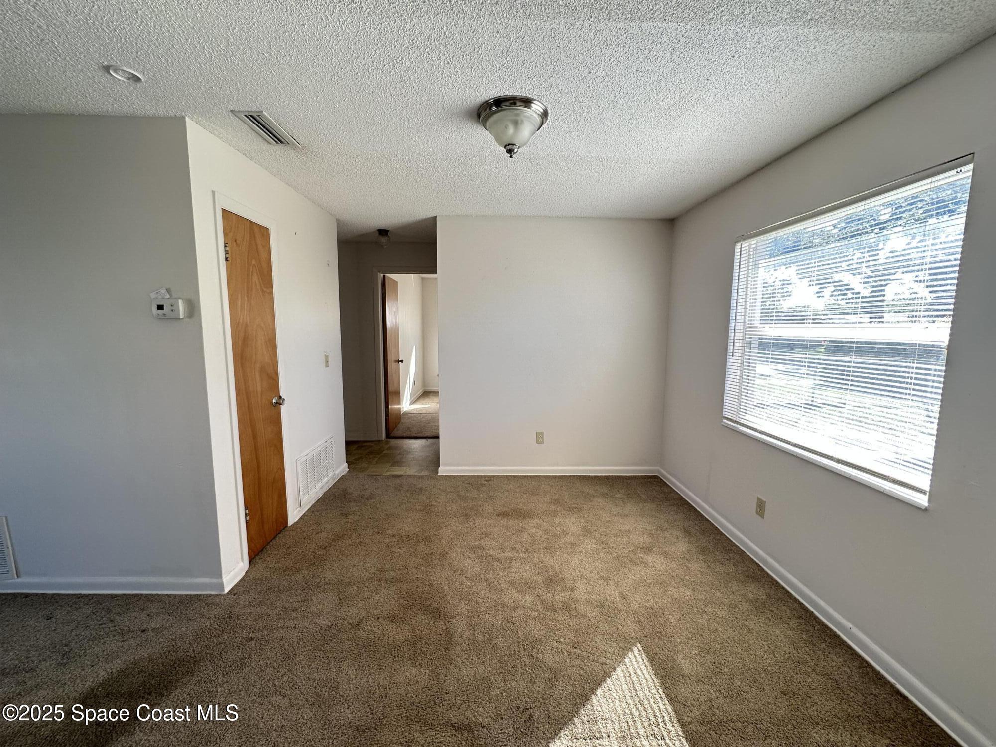 905 Grant Road Titusville, FL 32780 - Photo 18 of 30 a view of an empty room with a window