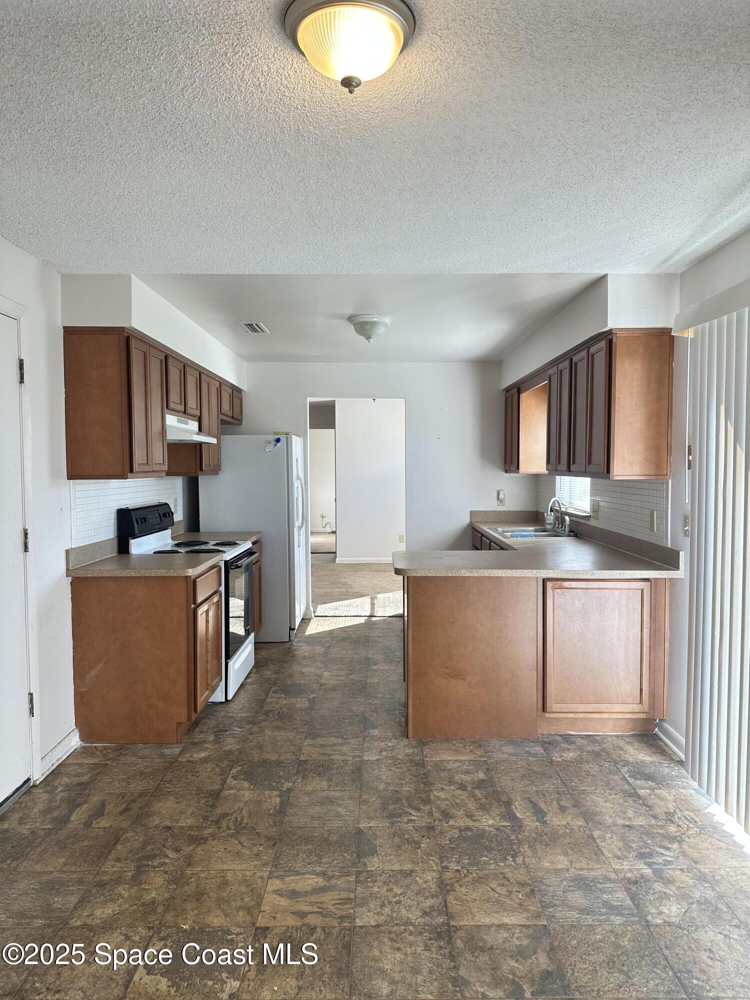 905 Grant Road Titusville, FL 32780 - Photo 21 of 30 a kitchen with stainless steel appliances granite countertop a stove a sink dishwasher and a refrigerator