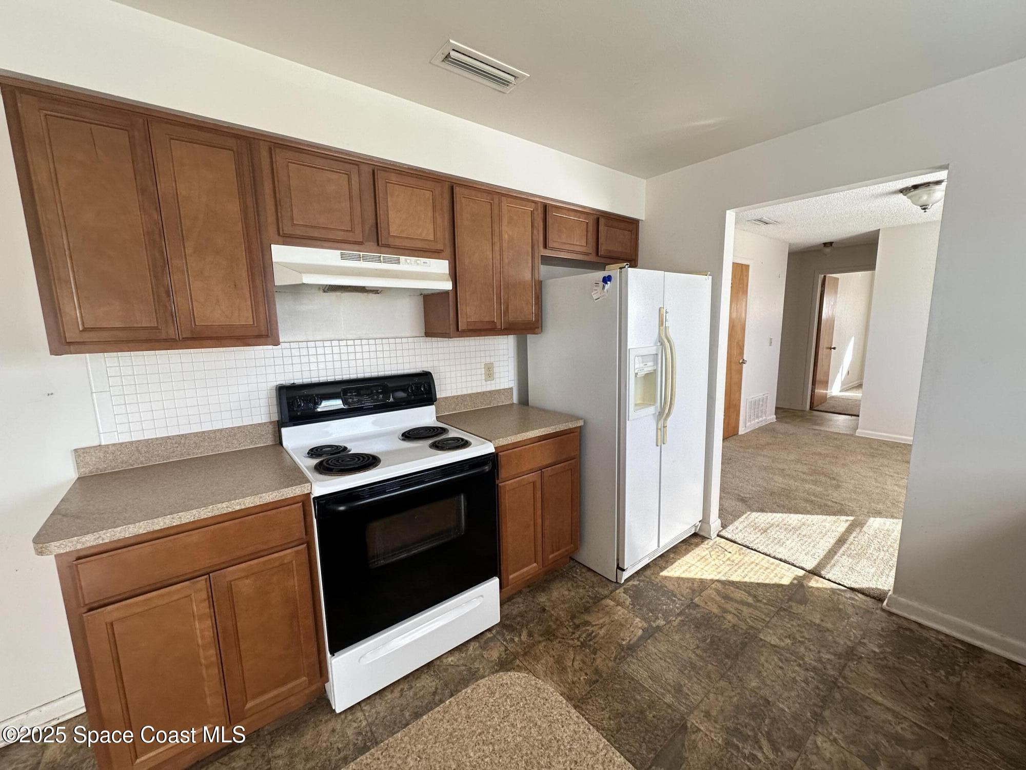 905 Grant Road Titusville, FL 32780 - Photo 23 of 30 a kitchen with stainless steel appliances granite countertop a stove a refrigerator and a sink
