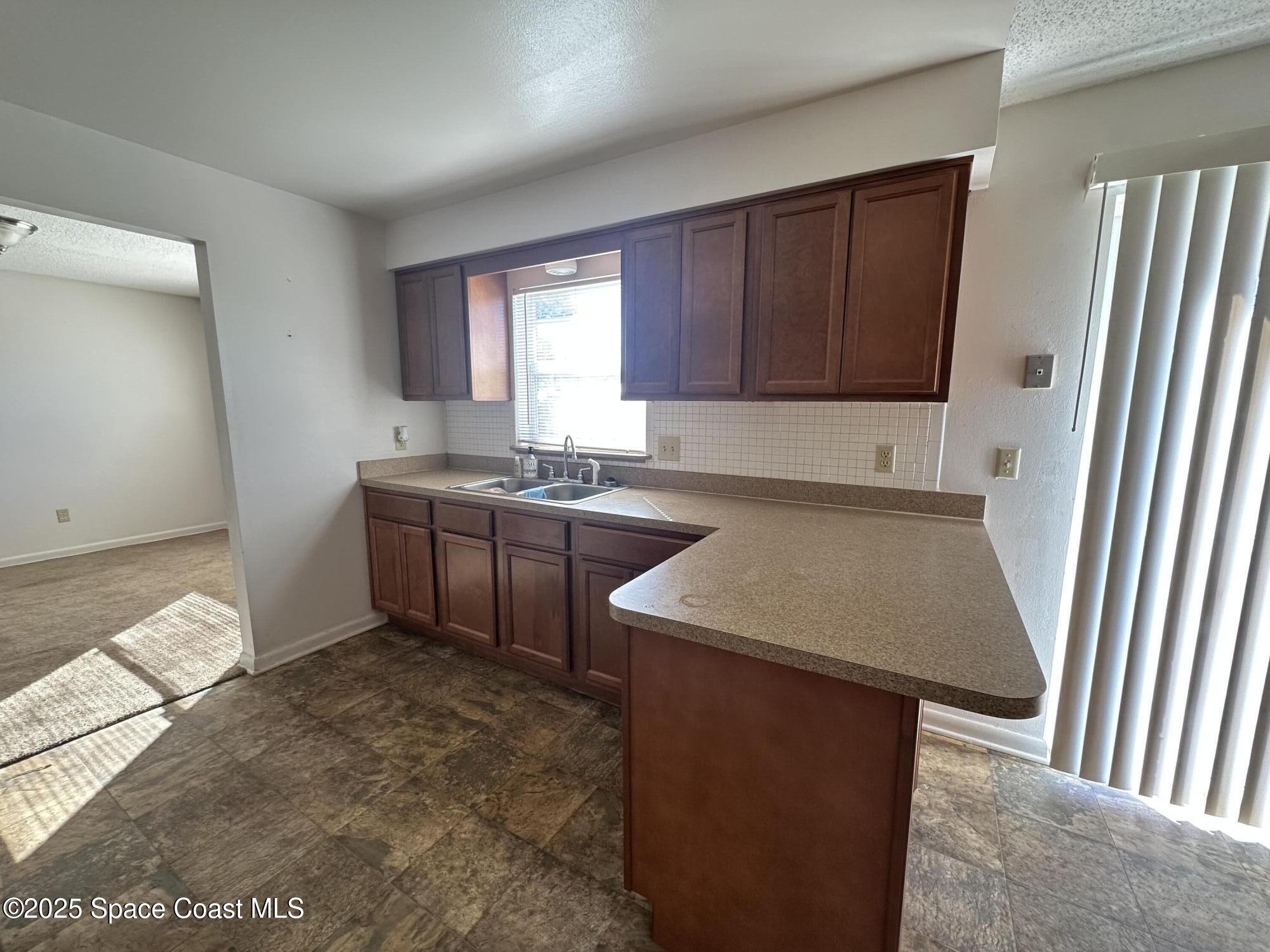 905 Grant Road Titusville, FL 32780 - Photo 24 of 30 a kitchen with a sink a stove and cabinets