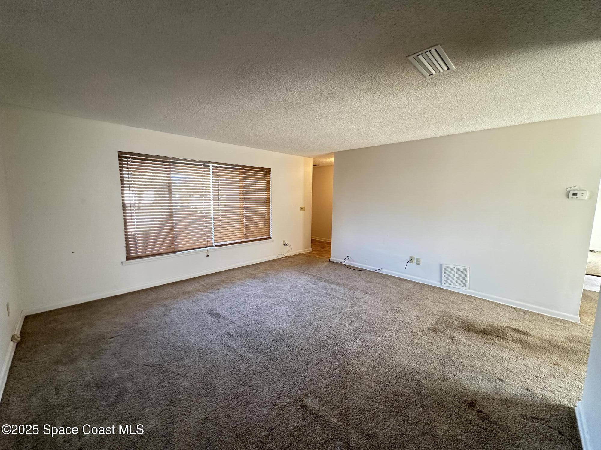 905 Grant Road Titusville, FL 32780 - Photo 8 of 30 an empty room with a empty space and windows