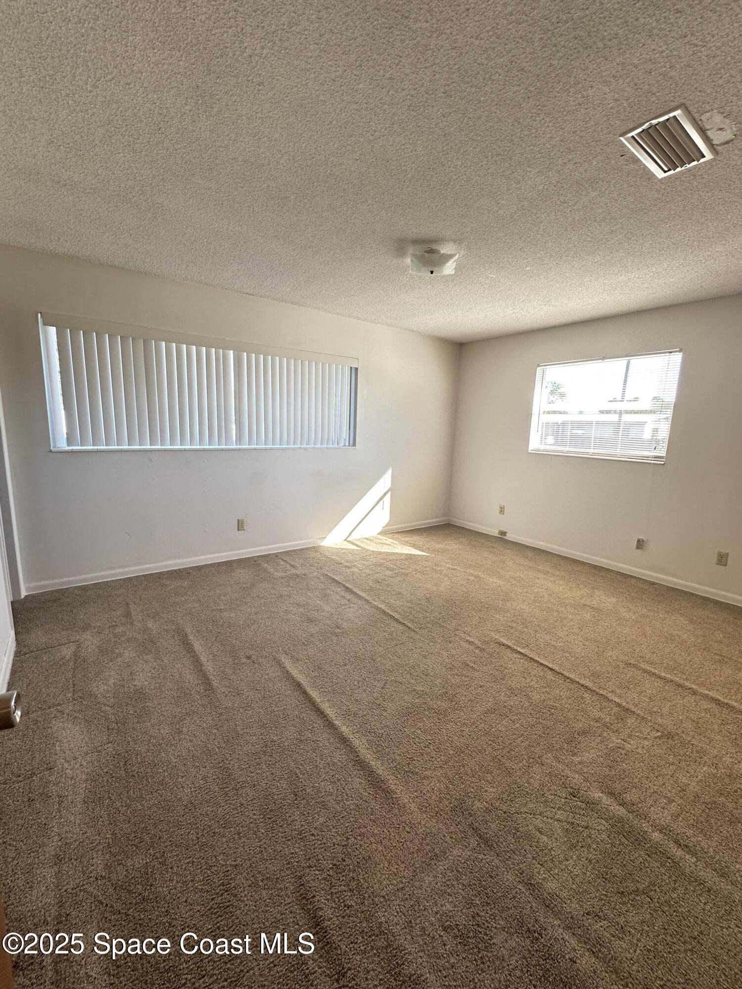 905 Grant Road Titusville, FL 32780 - Photo 9 of 30 an empty room with windows
