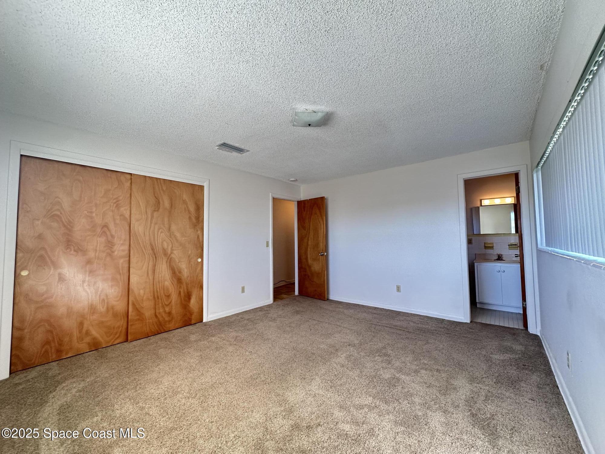 905 Grant Road Titusville, FL 32780 - Photo 10 of 30 an empty room with closet and windows