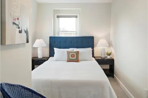 a bed sitting in a bedroom next to a window with yard