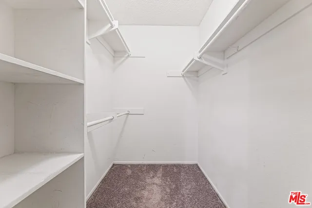 a view of walk in closet with empty racks