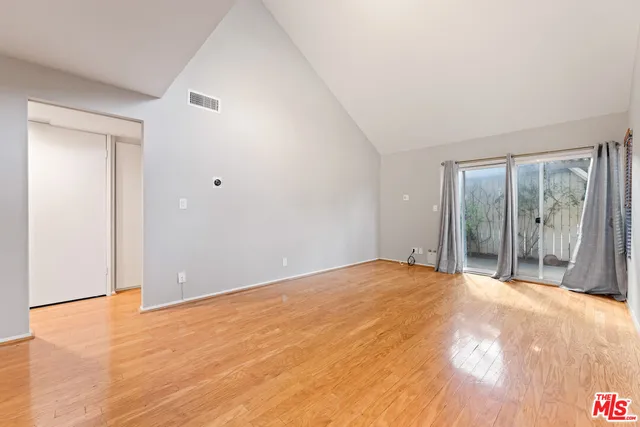 a view of an empty room with wooden floor