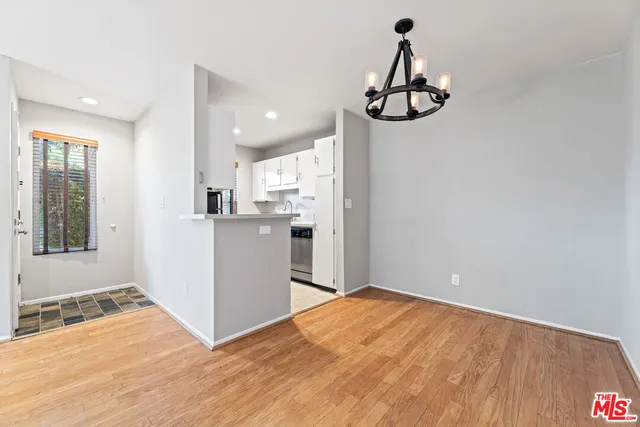 a kitchen with white cabinets and wooden floor