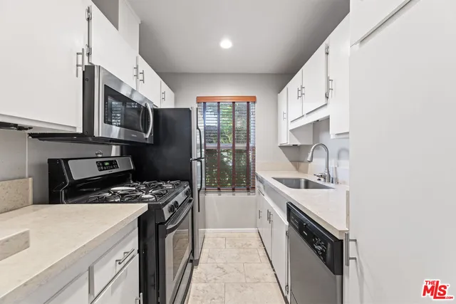 a kitchen with stainless steel appliances a sink stove and cabinets