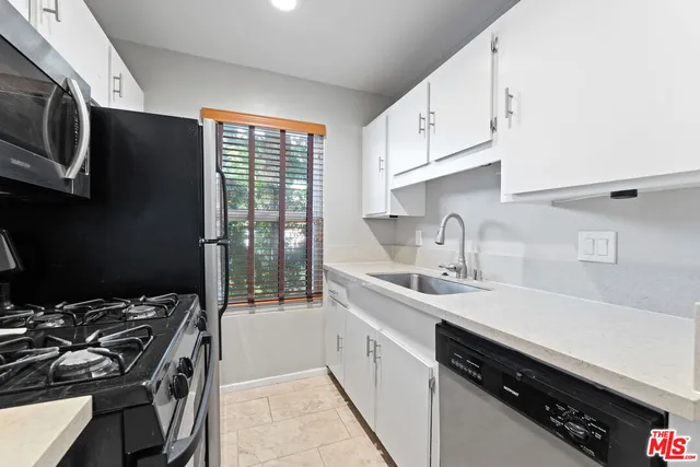 a kitchen with a sink stove top oven and cabinets
