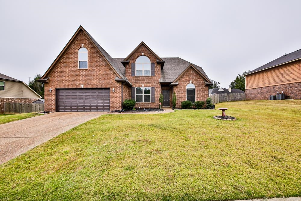 6839 Hare Pointe Bartlett, TN 38002 - Photo 4 of 35 a front view of a house with a garden and tree