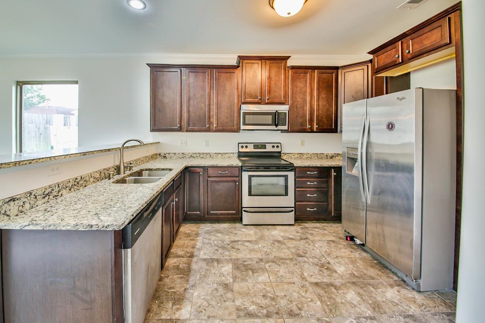 6839 Hare Pointe Bartlett, TN 38002 - Photo 8 of 35 a kitchen with stainless steel appliances granite countertop a stove a sink dishwasher a refrigerator and a oven with wooden floor