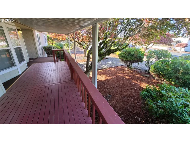 a view of a balcony with wooden floor and fence