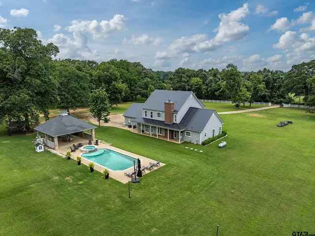 an aerial view of a house with a garden and trees