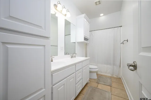 an empty room with a ceiling fan and carpet