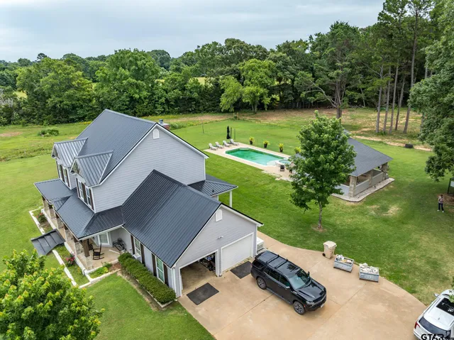 an aerial view of a house with a yard and trees