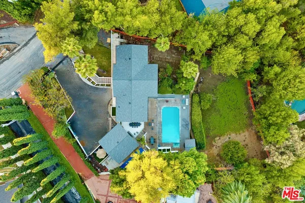an aerial view of a house with swimming pool and garden