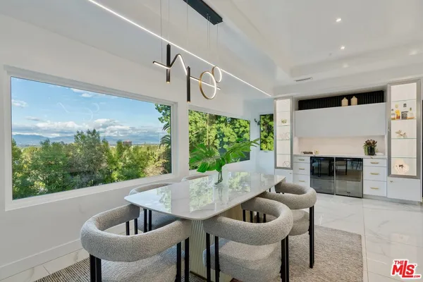 a kitchen with kitchen island granite countertop a sink white cabinets and stainless steel appliances
