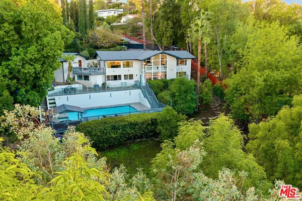 an aerial view of a house with swimming pool and garden