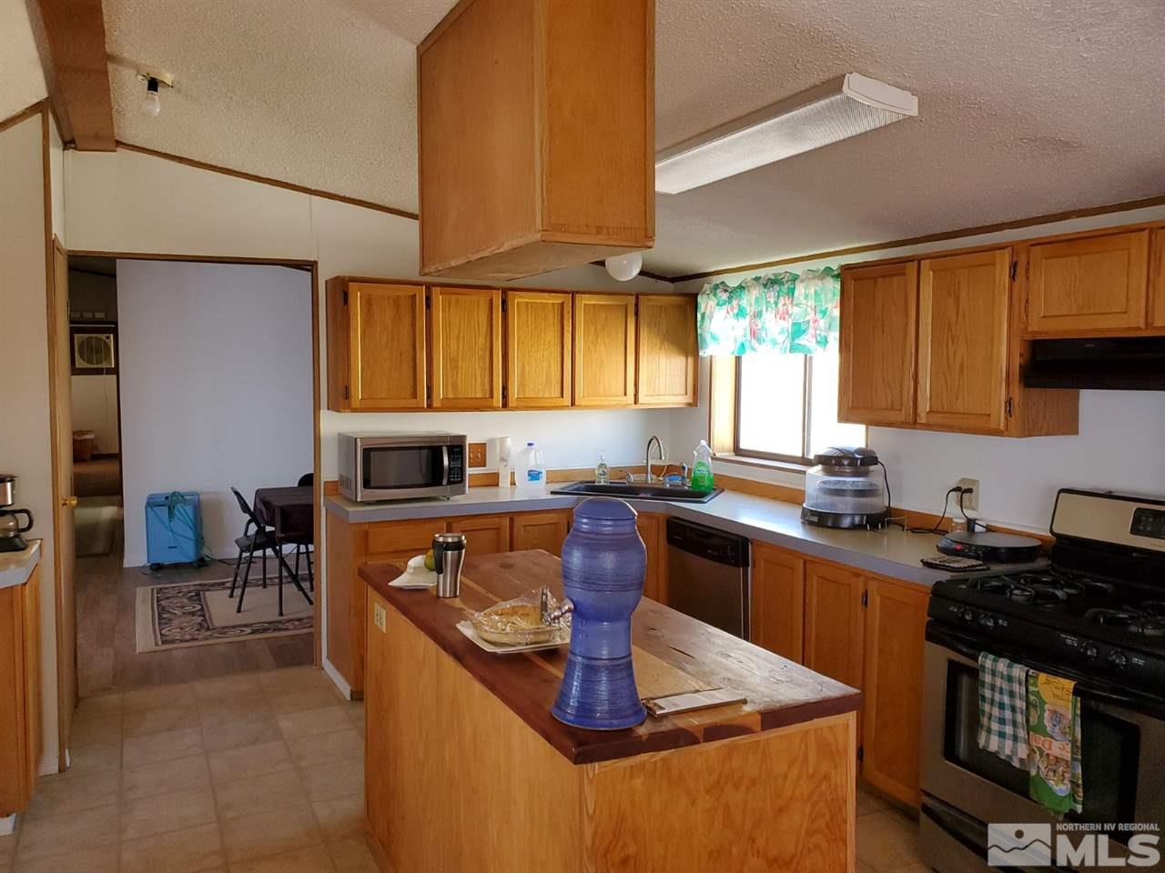 132 Lucille Drive Walker Lake, NV 89415 - Photo 16 of 36 a kitchen with stainless steel appliances granite countertop sink stove top oven and cabinets