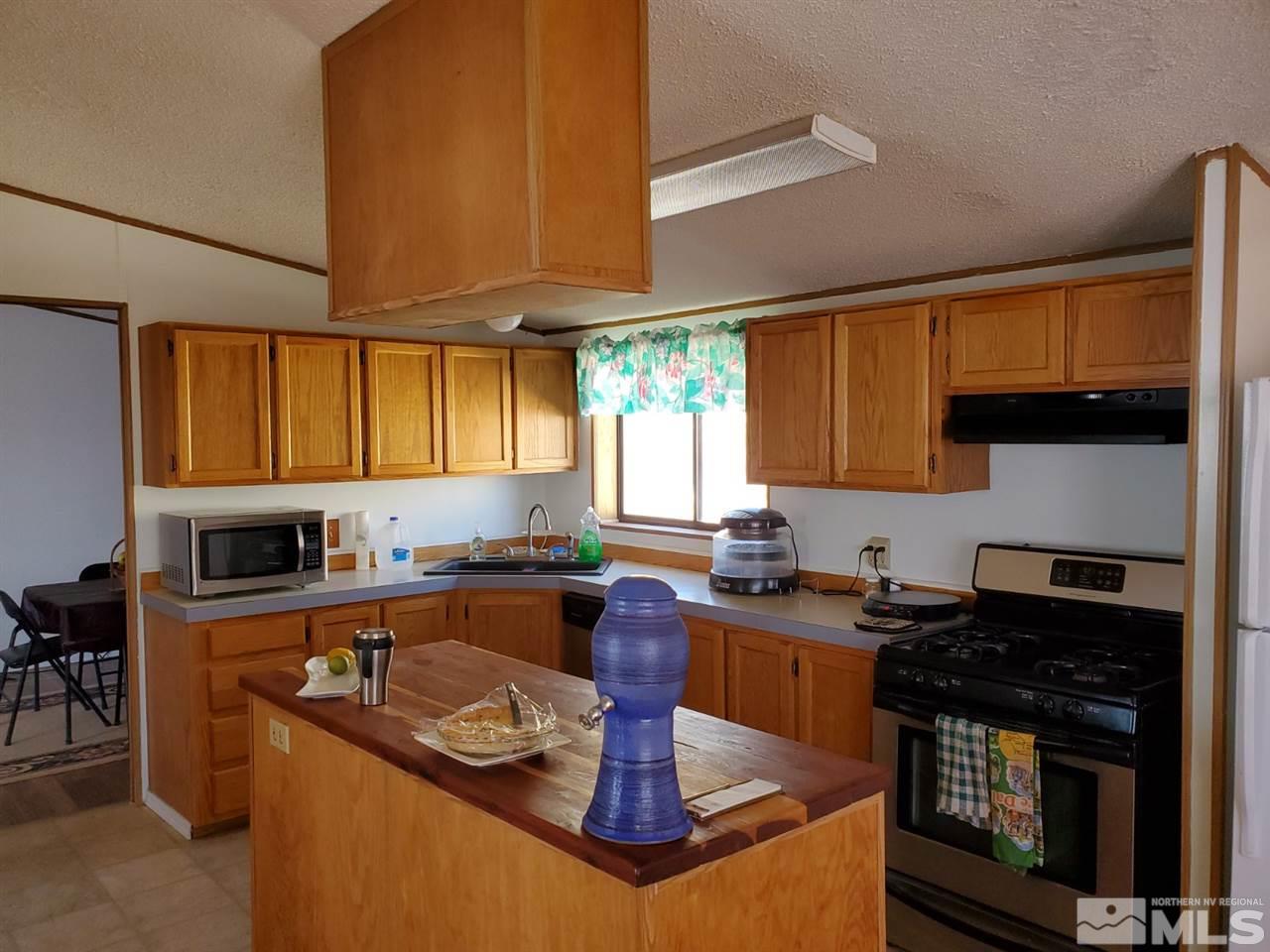 132 Lucille Drive Walker Lake, NV 89415 - Photo 17 of 36 a kitchen with granite countertop a sink a stove and cabinets
