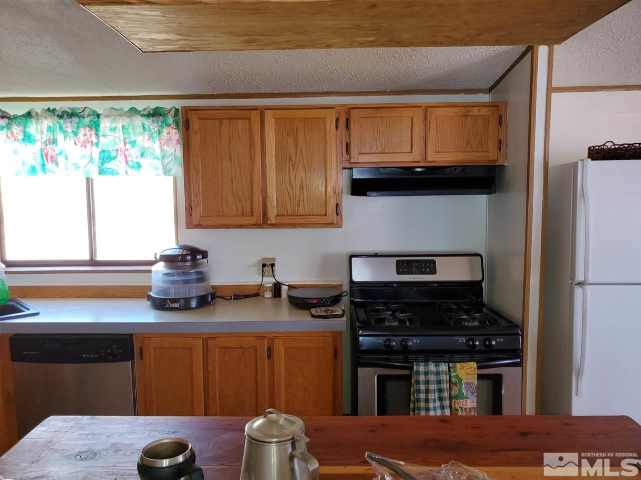132 Lucille Drive Walker Lake, NV 89415 - Photo 18 of 36 a kitchen with stainless steel appliances granite countertop a stove a sink and a microwave