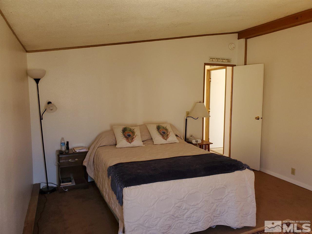 132 Lucille Drive Walker Lake, NV 89415 - Photo 31 of 36 a bedroom with a bed and a refrigerator