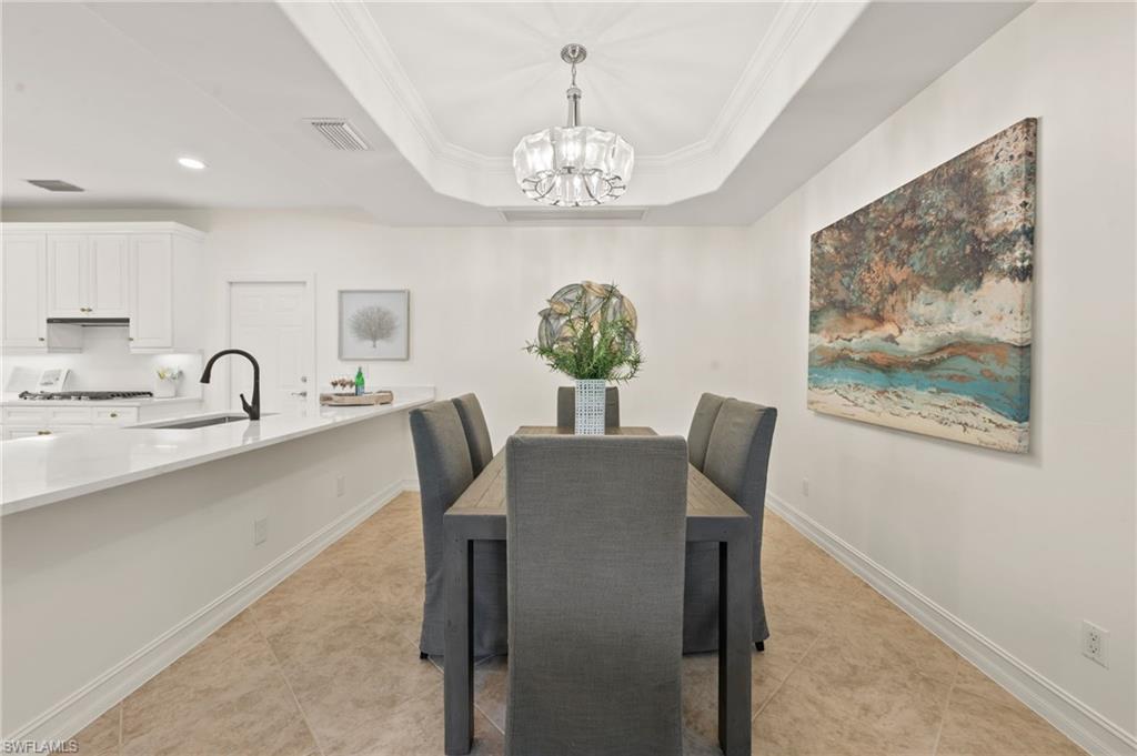 2886 Castillo Court, Unit 101 Naples, FL 34109 - Photo 11 of 45 a view of a dining room with furniture and chandelier