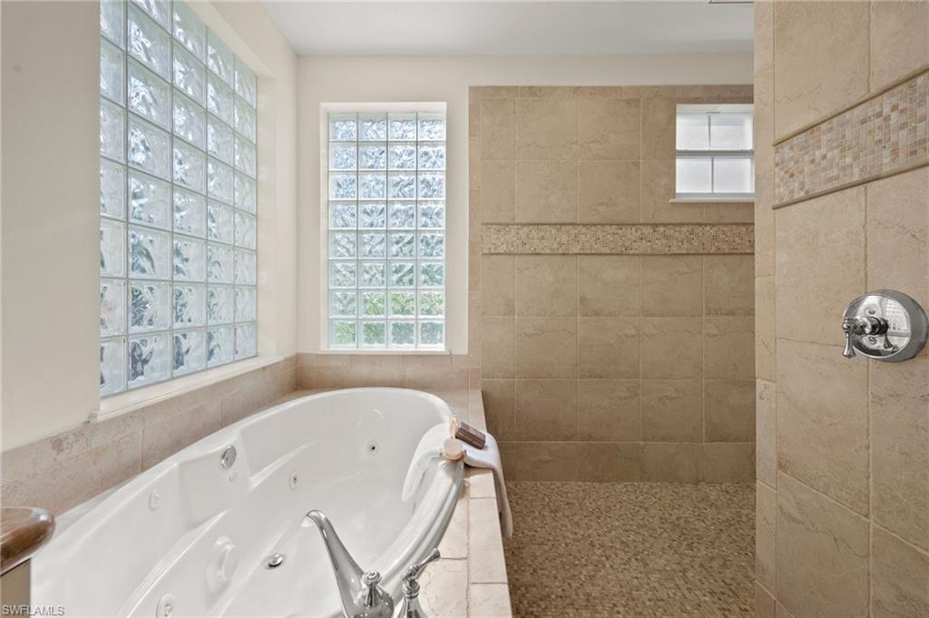 2886 Castillo Court, Unit 101 Naples, FL 34109 - Photo 17 of 45 a bathroom with a tub a window and a shower