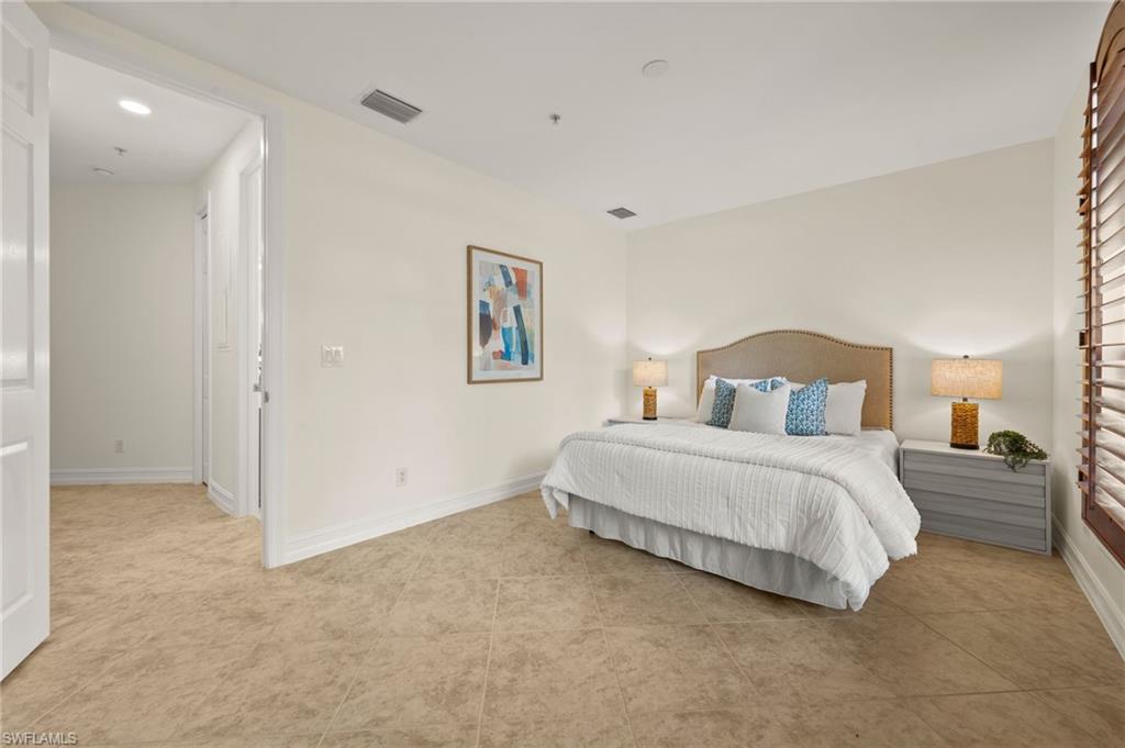 2886 Castillo Court, Unit 101 Naples, FL 34109 - Photo 23 of 45 a bedroom with a bed and a painting