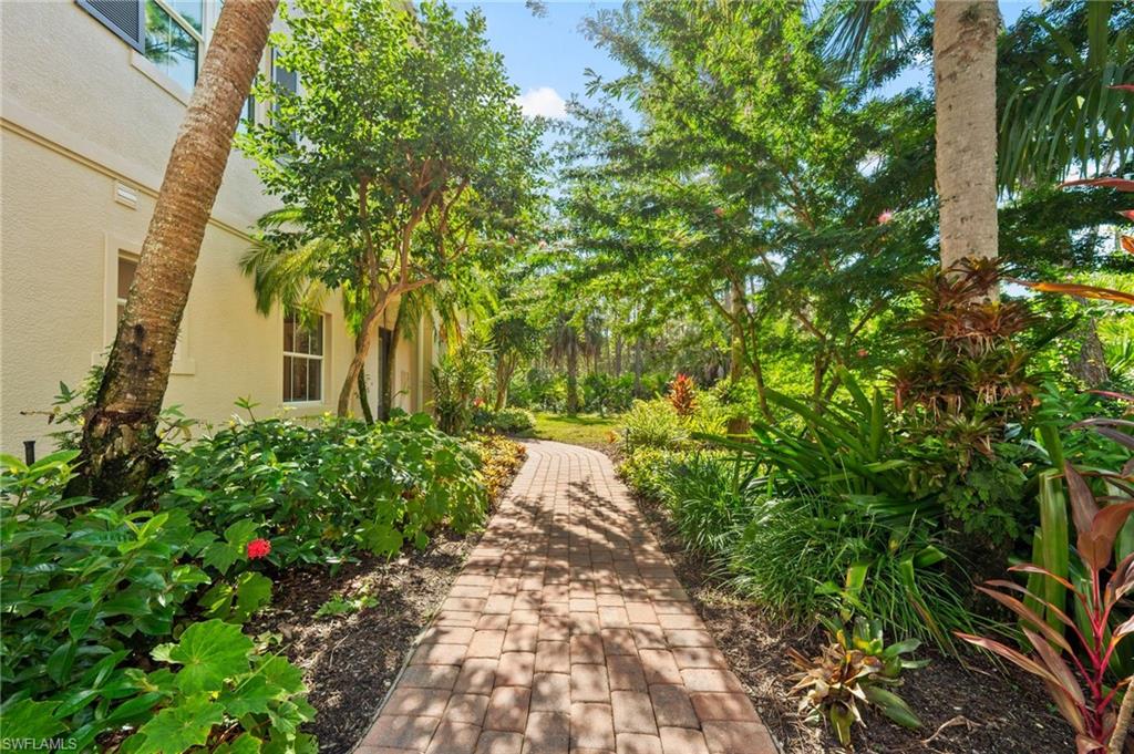 2886 Castillo Court, Unit 101 Naples, FL 34109 - Photo 29 of 45 a view of a yard with plants and large trees