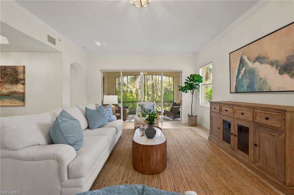 2886 Castillo Court, Unit 101 Naples, FL 34109 - Photo 5 of 45 a living room with furniture a fireplace and a painting