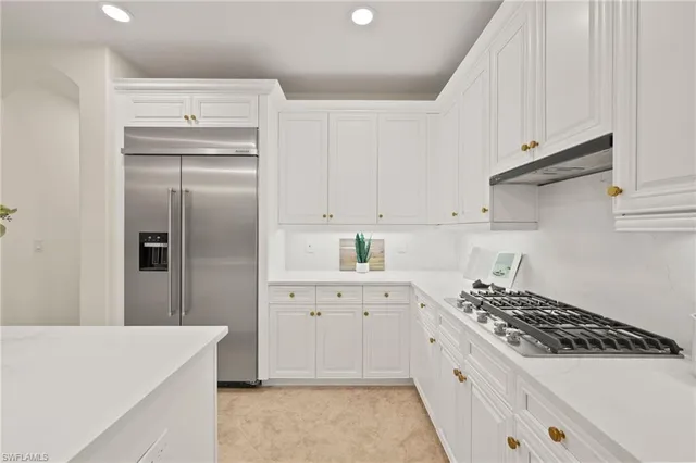 a kitchen with white cabinets a sink dishwasher and white appliances