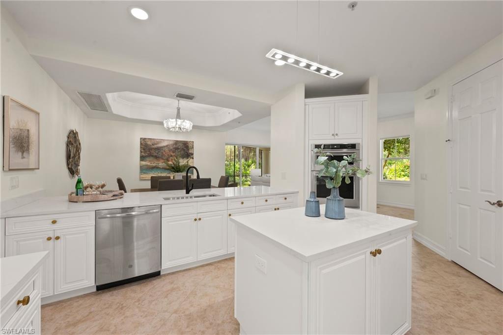 2886 Castillo Court, Unit 101 Naples, FL 34109 - Photo 9 of 45 a kitchen with white cabinets a sink dishwasher and white appliances