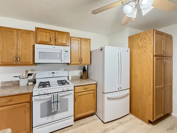 a kitchen with a refrigerator a stove a sink and cabinets